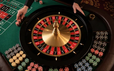 Live-Roulettetisch mit Dealer-H&auml;nden und Chips auf gr&uuml;nem Filz im WildRobin Casino Live Casino